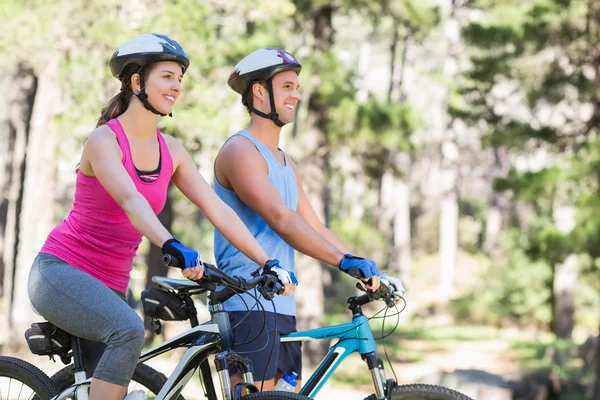 Happy man and woman riding bicycles — Stock Photo, Image