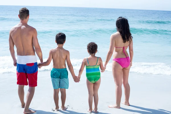 Familjen står på havsstranden — Stockfoto