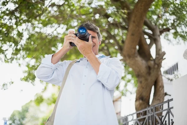 Hombre usando cámara contra árbol — Foto de Stock