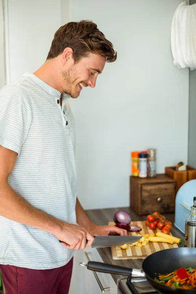 Ung man skära grönsaker — Stockfoto