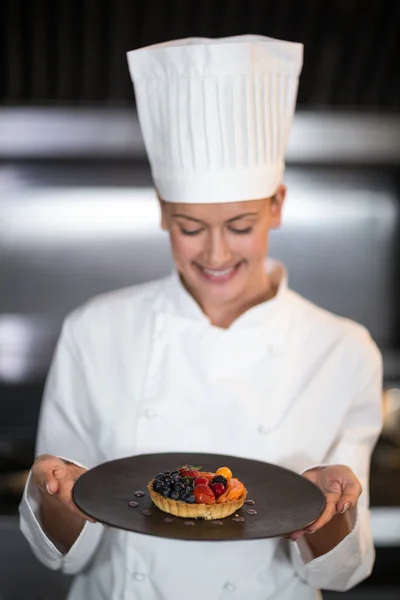 Female chef holding plate of dessert — Stock Photo, Image