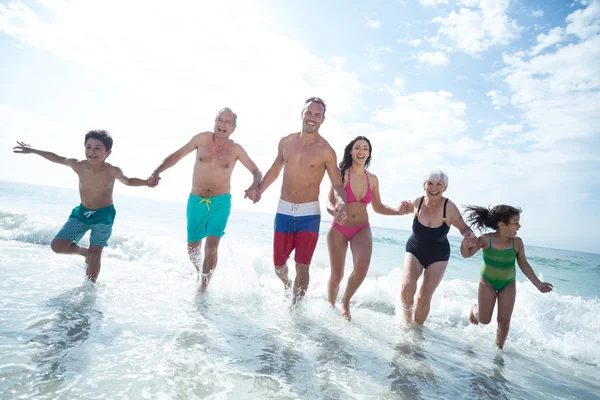 Familia corriendo en la playa — Foto de Stock