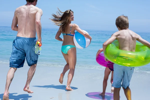 Familie rennt am Strand in Richtung Meer — Stockfoto