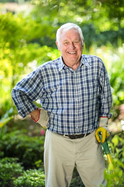 Senior man met apparatuur in tuin — Stockfoto