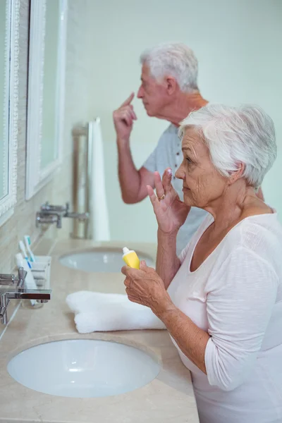 Senior couple applying cream — Stock Photo, Image