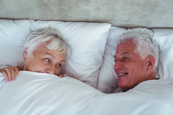 Couple looking at each other while lying — Stock Photo, Image