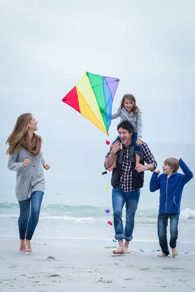 Familie met kite genieten op zee kust — Stockfoto