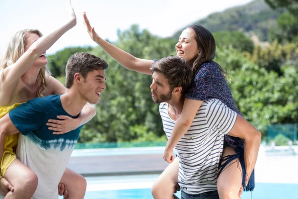 Homens dando porquinho de volta para as mulheres — Fotografia de Stock