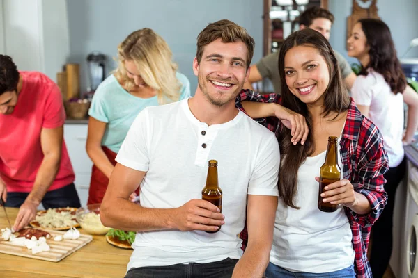 Casal segurando garrafas de cerveja em casa — Fotografia de Stock