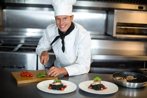 Chef guapo rebanando albahaca — Foto de Stock