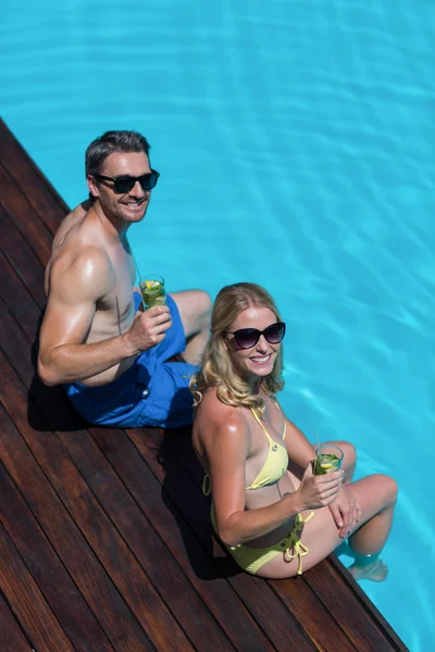 Paar zitten aan zwembad kant — Stockfoto