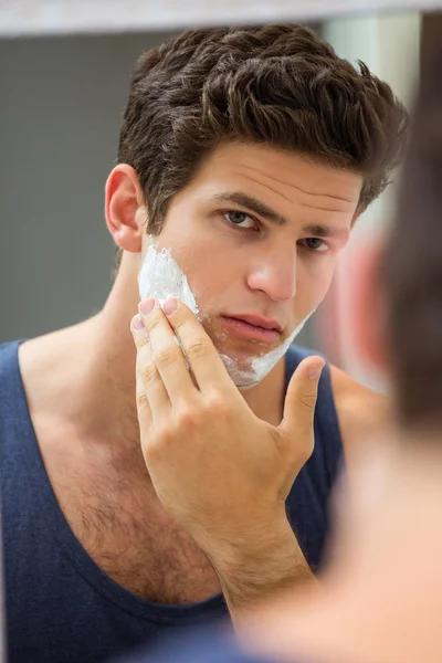 Uomo che applica schiuma da barba sul viso — Foto Stock