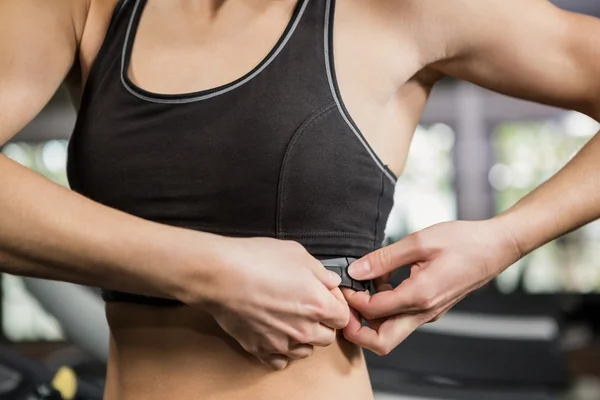 Woman in gym wearing heart rate monitor — Stock Photo, Image