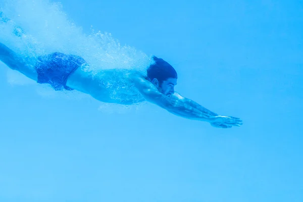 Man simmar under vattnet i poolen — Stockfoto