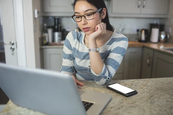 Wanita yang menggunakan laptop di dapur — Stok Foto