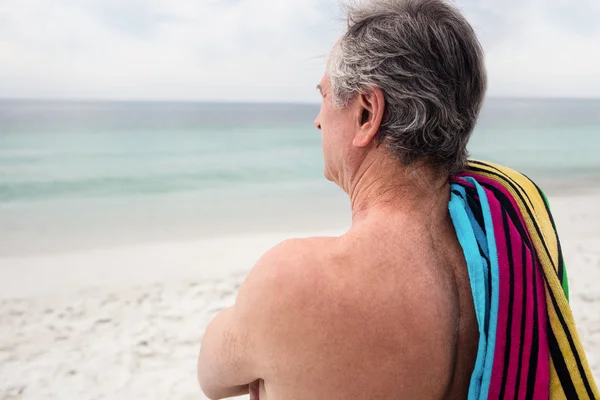 Старший мужчина стоит на пляже — стоковое фото