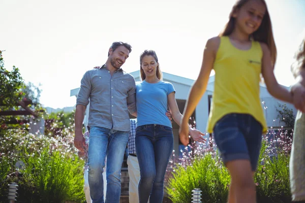 Couple heureux marchant avec la famille contre la maison — Photo