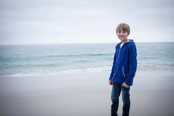 Gutt som står alene på stranden – stockfoto