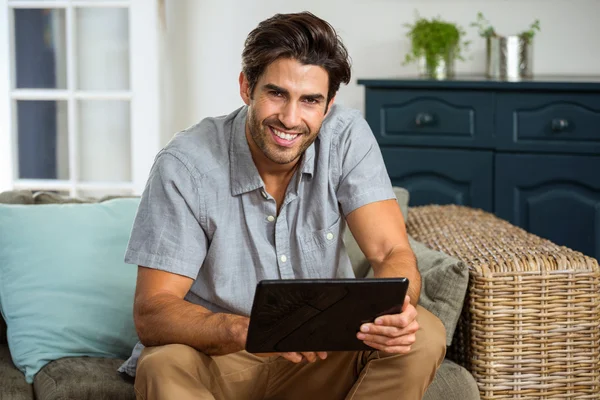 Jeune homme souriant avec tablette — Photo