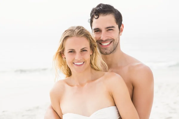 Gelukkige paar omarmen op het strand — Stockfoto