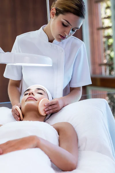 Masseuse cleaning woman face with cotton swabs — Stock Photo, Image