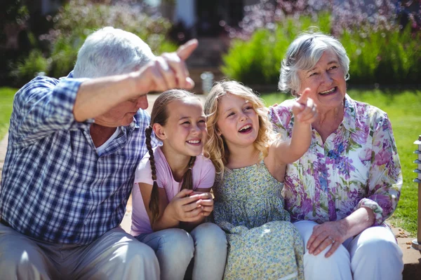 Ragazze allegre con i nonni mentre seduti nel cortile posteriore — Foto Stock