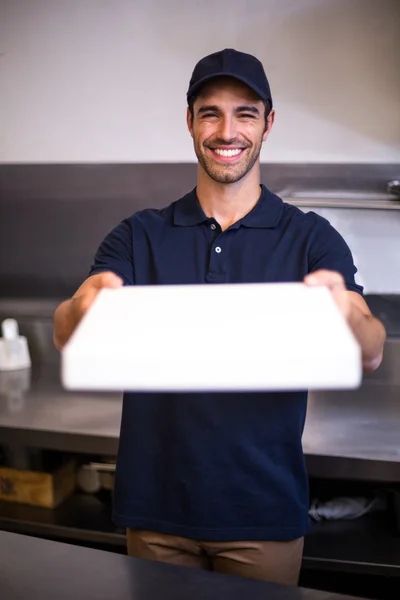 Pizza delivery man showing box — Stock Photo, Image