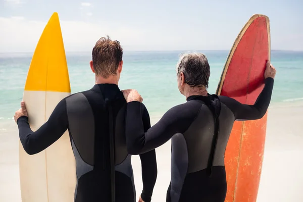 Отец и сын с досками для серфинга — стоковое фото