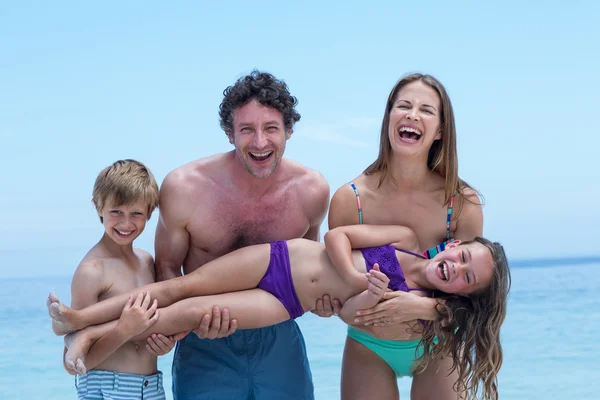 Alegre familia lifting chica en la orilla del mar —  Fotos de Stock