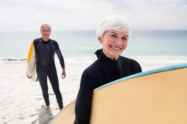 Seniorenpaar im Neoprenanzug mit Surfbrettern — Stockfoto