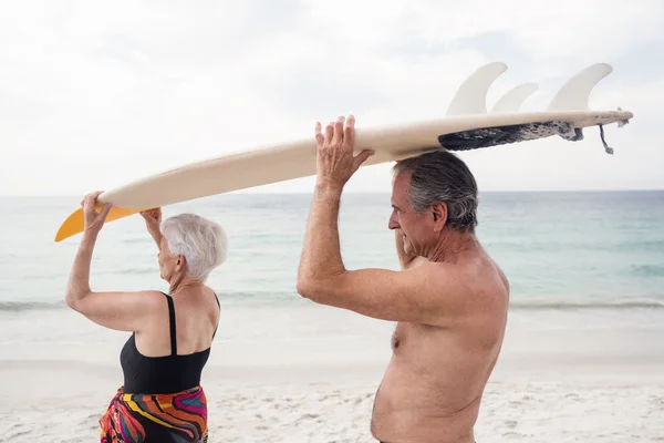 Senior paar dragende surfplank — Stockfoto