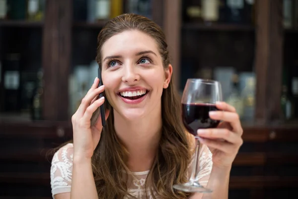 Γυναίκα που κρατά ποτήρι μιλάμε στο τηλέφωνο — Φωτογραφία Αρχείου