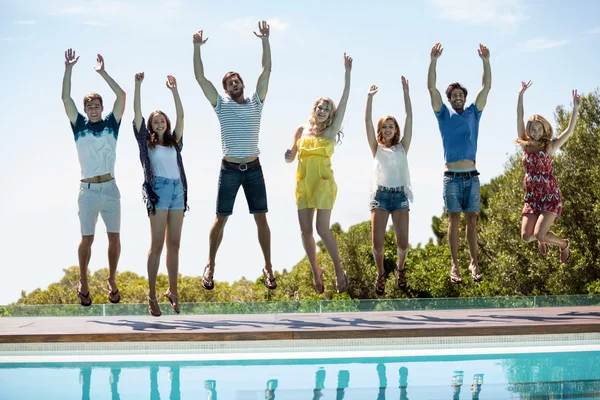 Amigos felices saltando cerca de la piscina —  Fotos de Stock