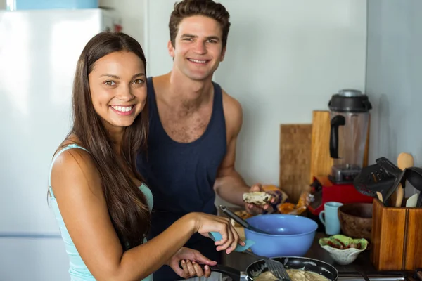 Couple cooking food in kitchen — Stock Photo, Image