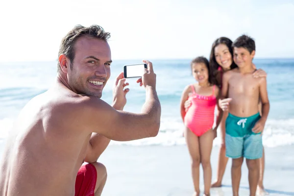 Homem sorrindo enquanto fotografa crianças — Fotografia de Stock