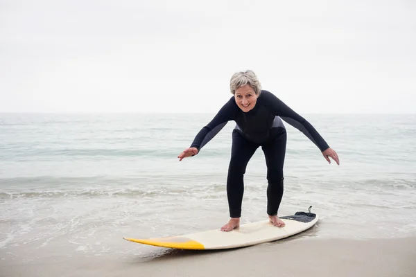 Femme senior surfant sur planche de surf — Photo