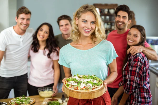 Žena hospodářství pizza s přáteli — Stock fotografie