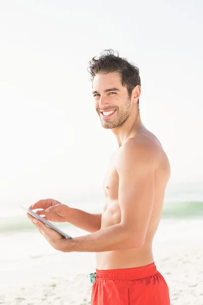 Ταιριάζει ο άνθρωπος χρησιμοποιώντας tablet στην παραλία — Φωτογραφία Αρχείου
