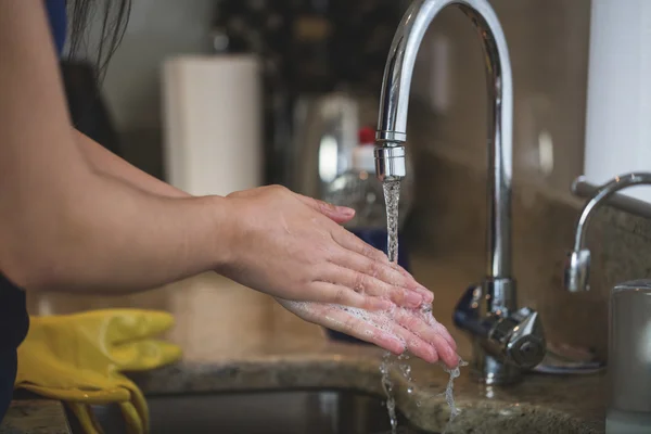 Mujer lavándose las manos en fregadero de cocina — Foto de Stock