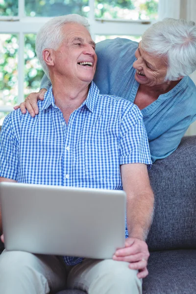 Sorrindo casal aposentado usando laptop — Fotografia de Stock