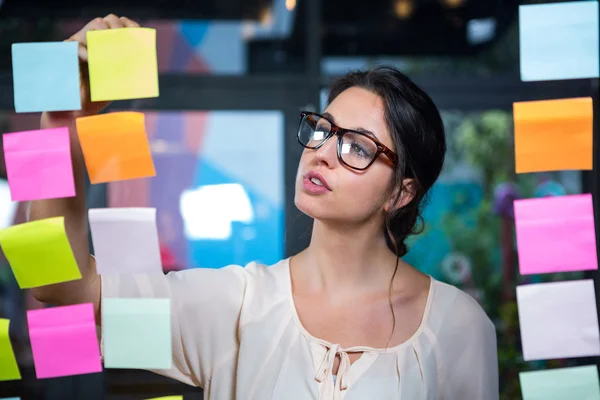 Empresaria escribiendo en nota adhesiva — Foto de Stock