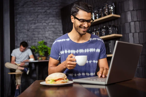 Mann benutzt Laptop und trinkt Kaffee — Stockfoto