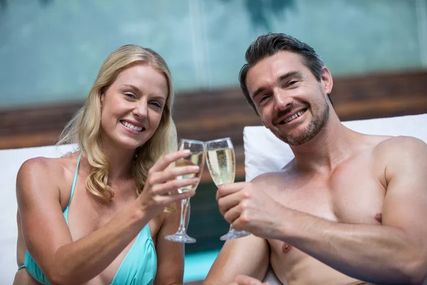 Couple sur chaise longue toasting champagne — Photo