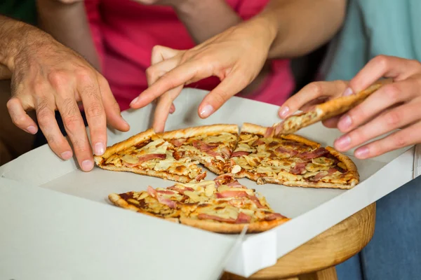Friends picking up piece of pizza — Stock Photo, Image