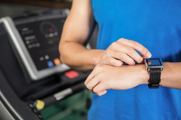 Člověk s použitím chytré hodinky na běžecký pás — Stock fotografie