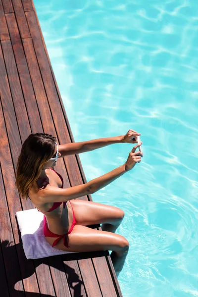 Mujer tomando selfie en borde de piscina — Foto de Stock