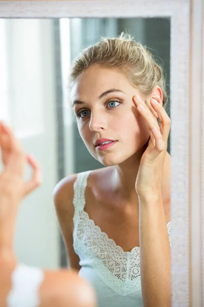 Frau checkt Haut im Badezimmer — Stockfoto