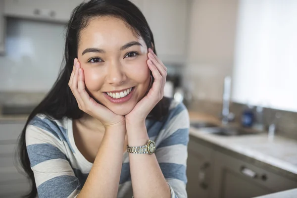 Happy woman sitting in kitchen — Stock Photo, Image