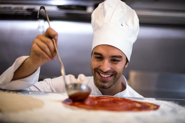 Pizza chef colocar molho na base — Fotografia de Stock