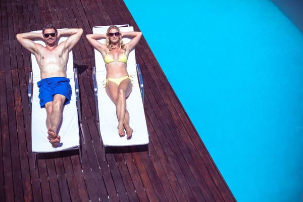 Couple relaxing on sun lounger — Stock Photo, Image